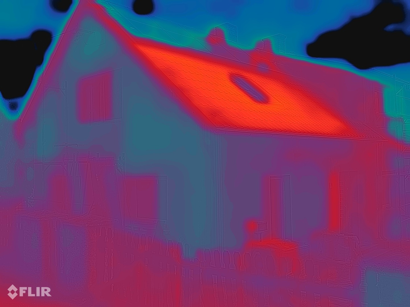 Image thermique FLIR de la même façade après le revêtement : surface du mur bleu-vert à violet