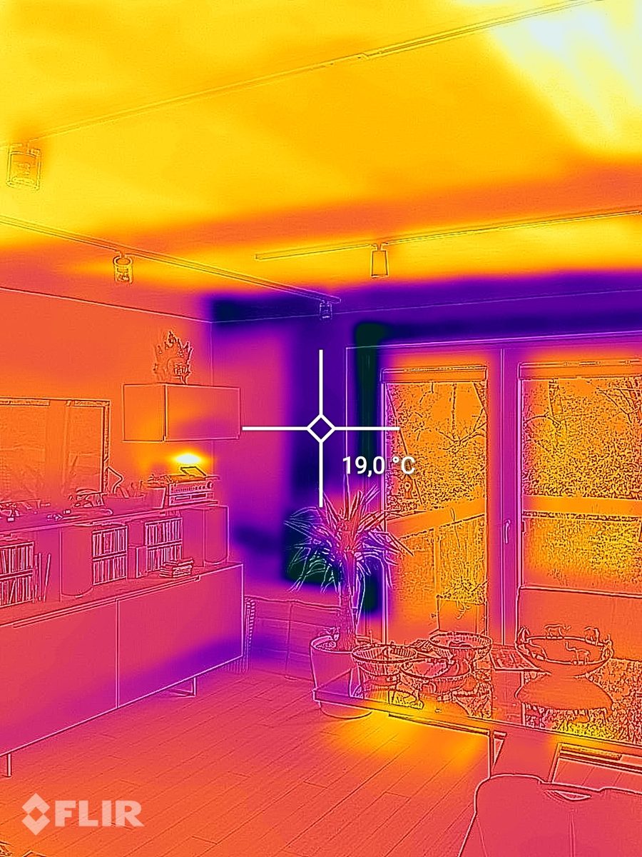 Thermographie d'un salon avec un plafond chaud grâce au chauffage par plafond et un point de mesure de 19,0 degrés au mur extérieur à côté de la porte-fenêtre.